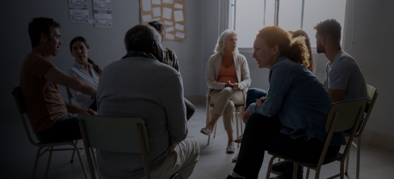 Eight people sitting in a circle talking